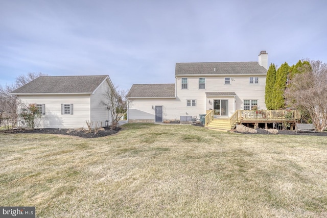 back of property featuring a wooden deck, a yard, central AC unit, and a chimney