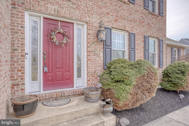 entrance to property featuring brick siding