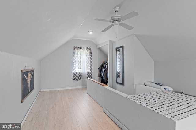 additional living space with lofted ceiling, light wood-style flooring, a ceiling fan, and baseboards