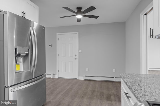 kitchen with a baseboard heating unit, dark wood finished floors, stainless steel refrigerator with ice dispenser, white cabinetry, and a ceiling fan