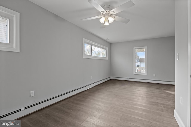 empty room with a baseboard heating unit, wood finished floors, and a ceiling fan