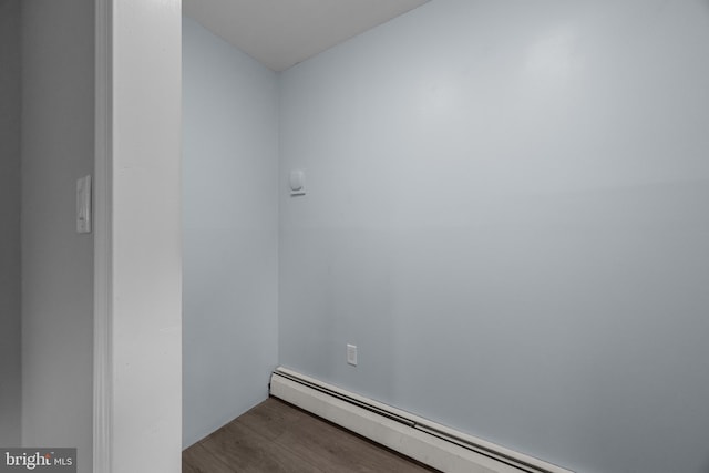 unfurnished room featuring baseboard heating and wood finished floors