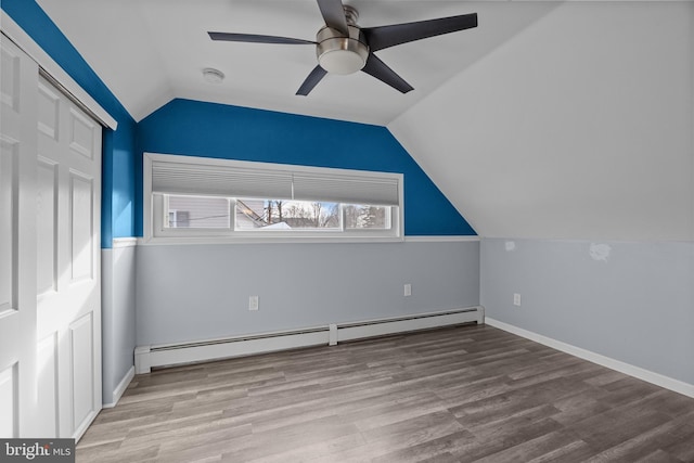 additional living space featuring ceiling fan, a baseboard heating unit, wood finished floors, and vaulted ceiling