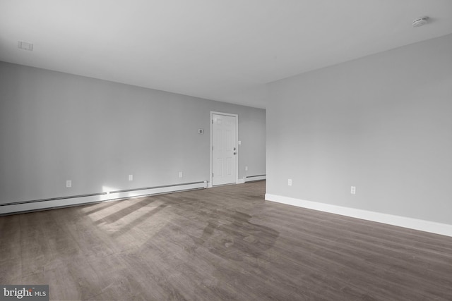 spare room with wood finished floors, baseboards, baseboard heating, and a baseboard radiator