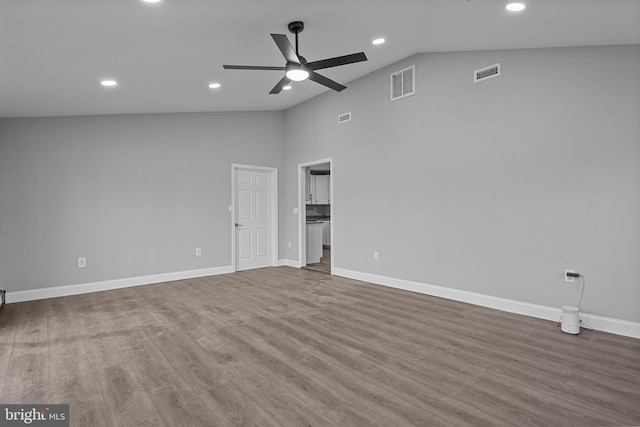 unfurnished room with visible vents, lofted ceiling, and wood finished floors