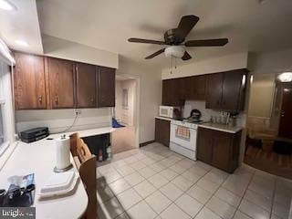 kitchen with white appliances, light tile patterned flooring, and light countertops