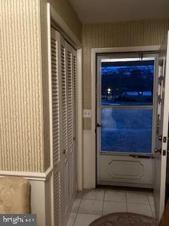 doorway to outside with tile patterned flooring