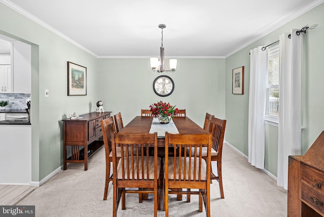 dining space featuring light colored carpet, baseboards, crown molding, and an inviting chandelier