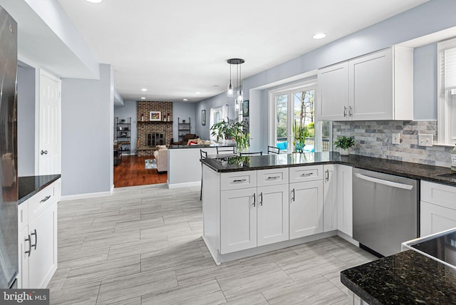 kitchen with tasteful backsplash, open floor plan, a peninsula, white cabinets, and stainless steel appliances