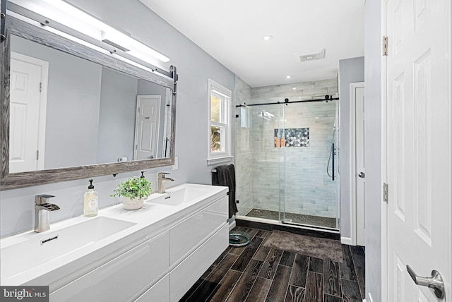 full bath featuring a stall shower, wood tiled floor, and a sink