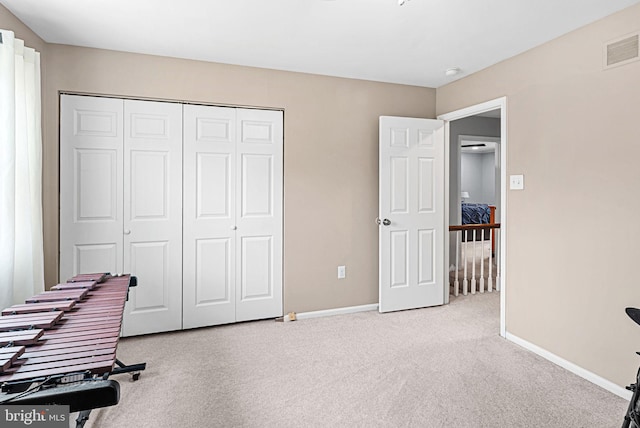 interior space featuring light carpet, visible vents, and baseboards