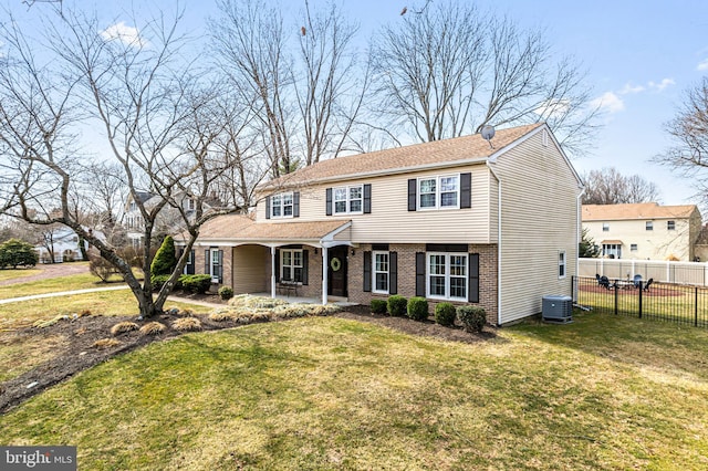 view of front of home featuring brick siding, central AC, a front lawn, and fence