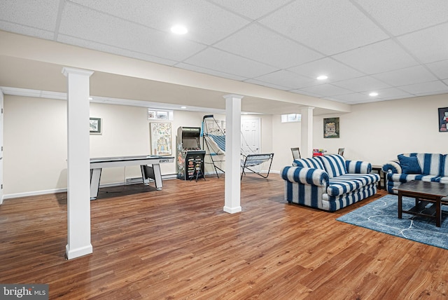 living room featuring wood finished floors, baseboards, and a drop ceiling