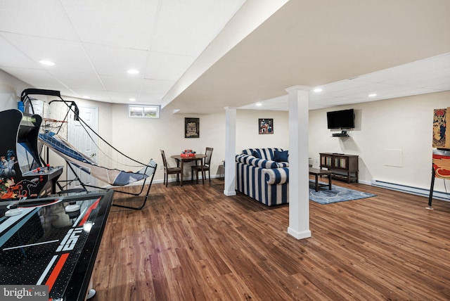 exercise room with a baseboard radiator, baseboards, and wood finished floors