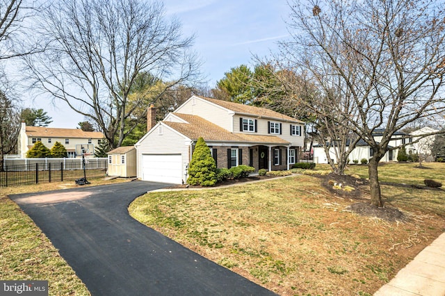 view of front facade with driveway, fence, an attached garage, a shingled roof, and brick siding