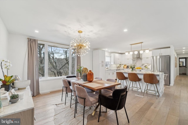 dining room with recessed lighting, baseboards, light wood-style floors, and an inviting chandelier