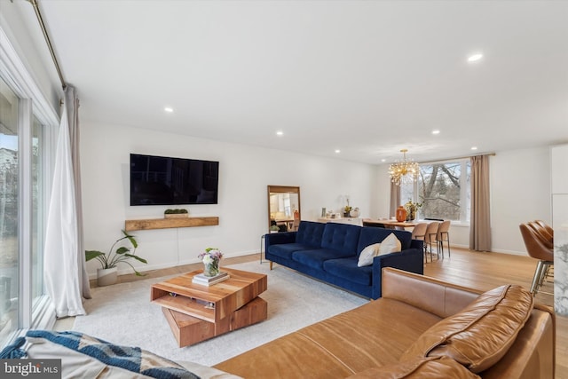 living area featuring light wood finished floors, a chandelier, recessed lighting, and baseboards