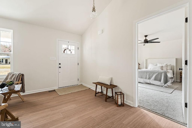 entrance foyer featuring lofted ceiling, light wood-style flooring, baseboards, and ceiling fan