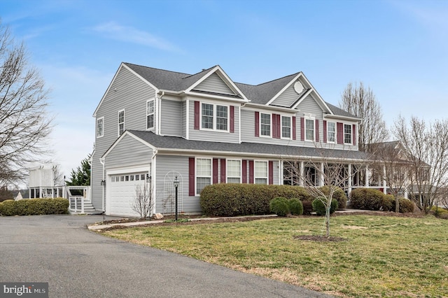 view of front of home with aphalt driveway, a garage, and a front yard