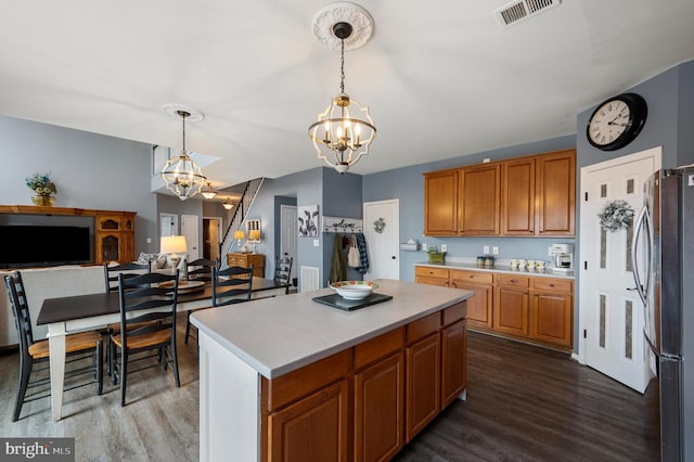 kitchen with a notable chandelier, light countertops, freestanding refrigerator, and visible vents