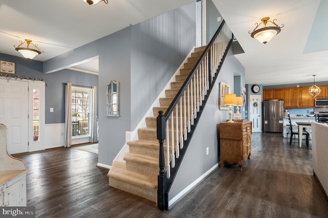 stairway with wood finished floors and baseboards