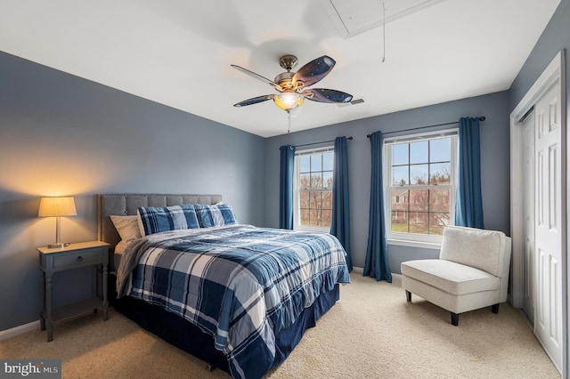 bedroom featuring visible vents, baseboards, attic access, a closet, and light colored carpet