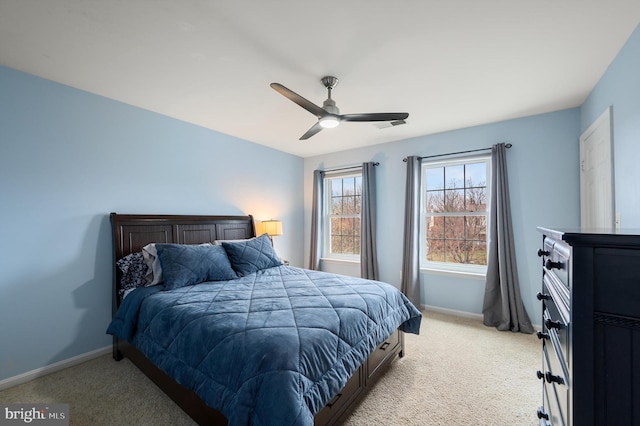 bedroom featuring light colored carpet, a ceiling fan, and baseboards