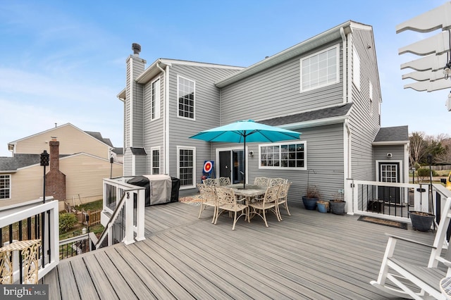 wooden deck with outdoor dining area and a grill