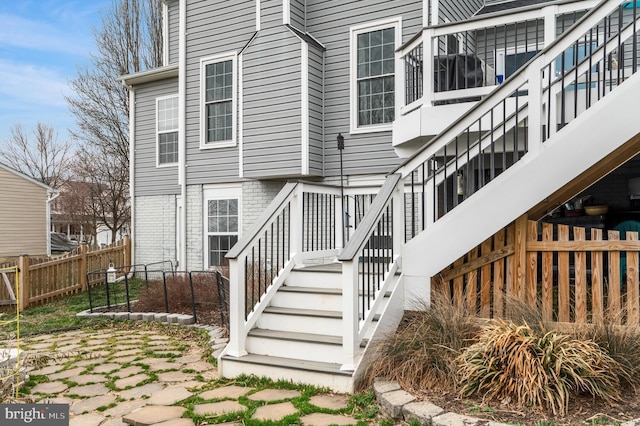 property entrance with brick siding and fence