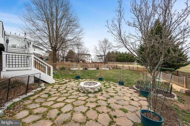 view of yard with a fenced backyard, stairway, an outdoor fire pit, and a patio