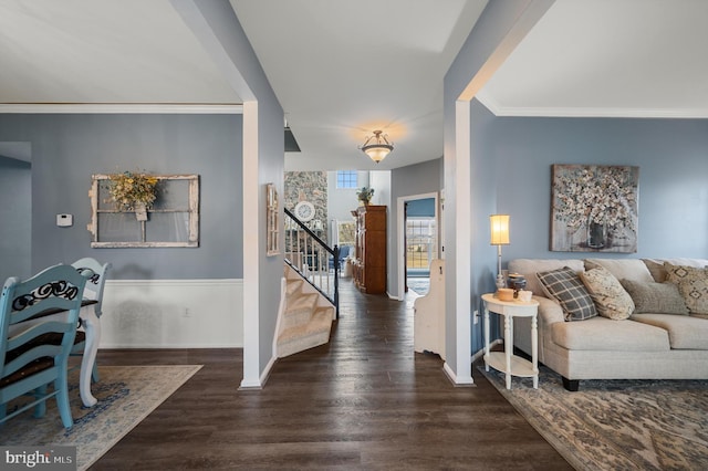 foyer entrance featuring stairs, wood finished floors, baseboards, and ornamental molding