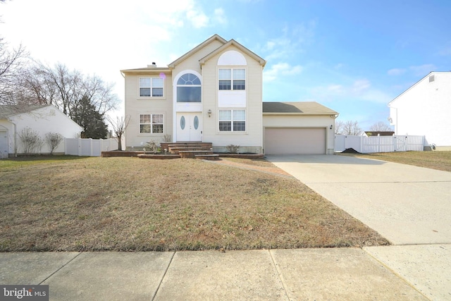 traditional-style home featuring a front yard, an attached garage, fence, and driveway