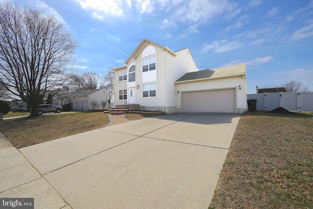 traditional-style home with concrete driveway, a gate, an attached garage, and fence