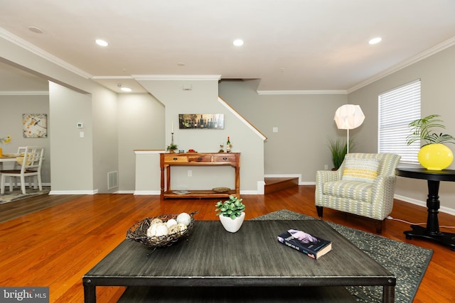 living area with recessed lighting, visible vents, ornamental molding, and wood finished floors