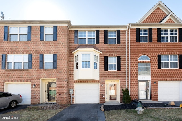 view of property featuring brick siding and driveway