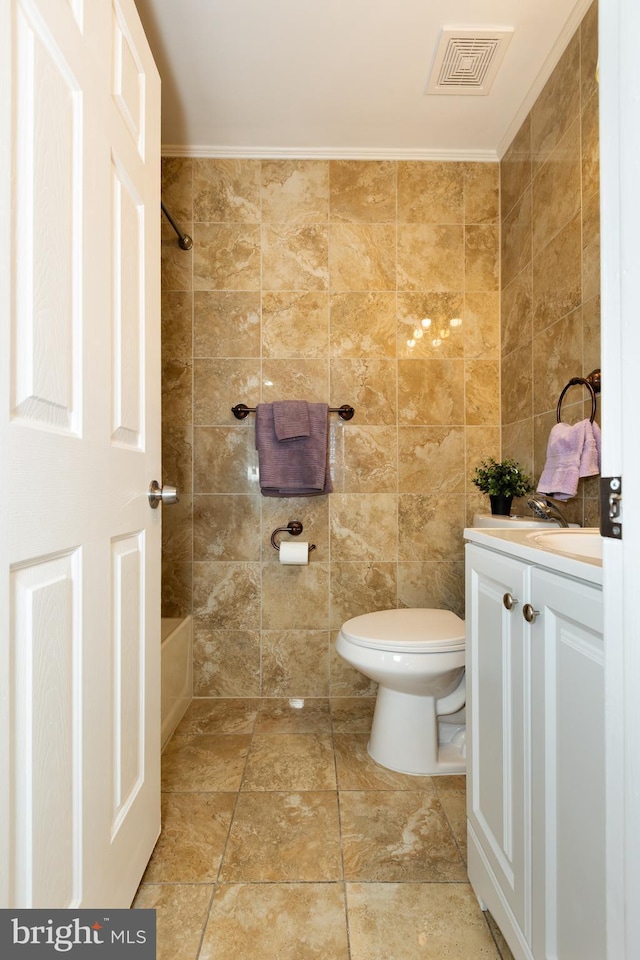 full bathroom with visible vents, toilet, tile walls, washtub / shower combination, and vanity