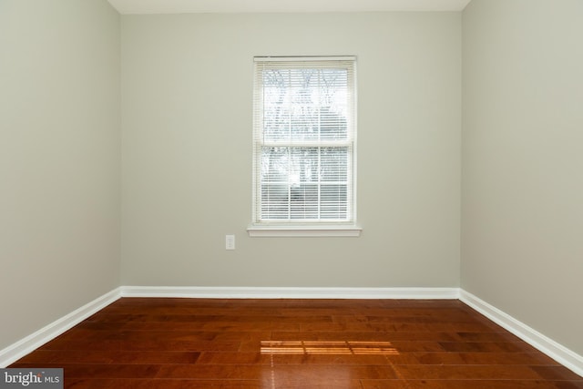 empty room with baseboards and wood finished floors