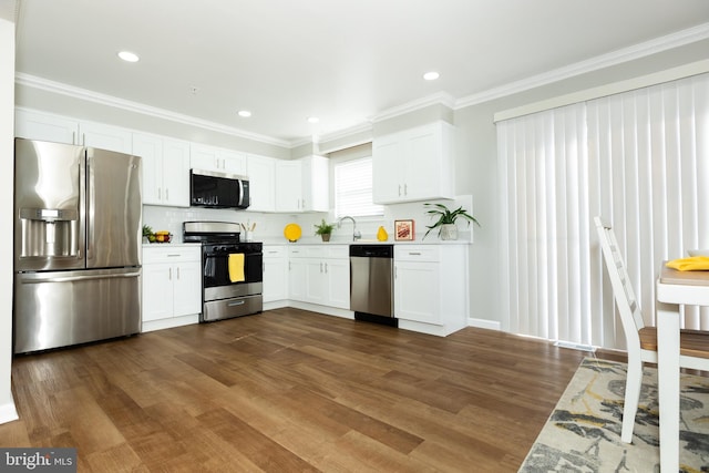 kitchen featuring a sink, dark wood finished floors, white cabinetry, stainless steel appliances, and light countertops