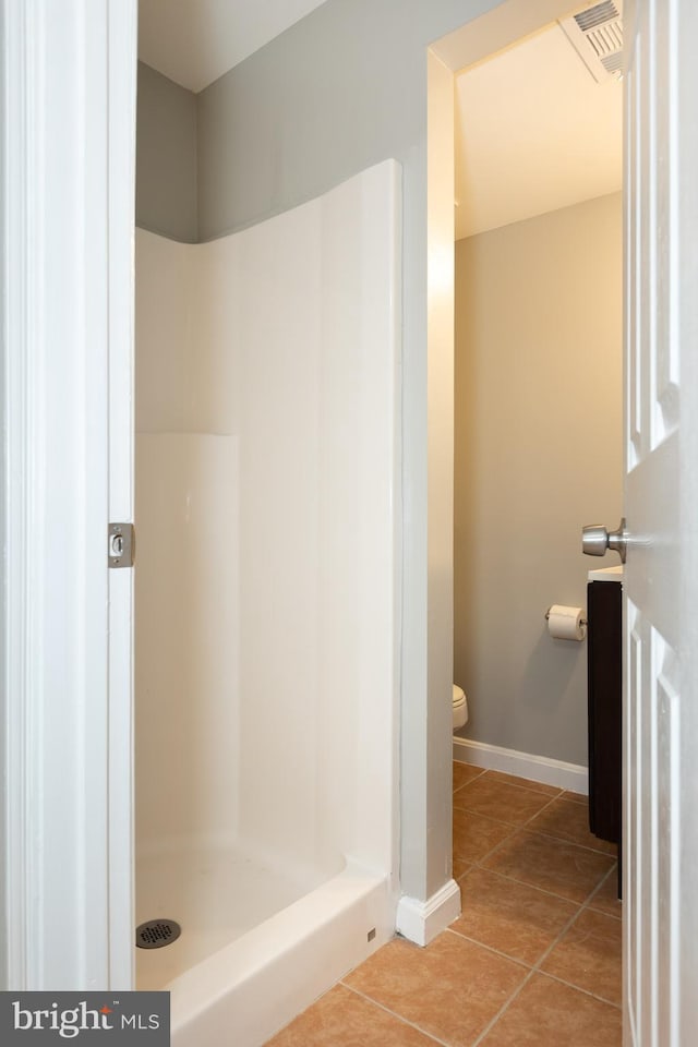 bathroom with baseboards, visible vents, tile patterned flooring, a shower stall, and toilet