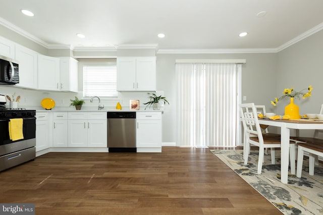 kitchen featuring dark wood-type flooring, white cabinetry, appliances with stainless steel finishes, crown molding, and light countertops