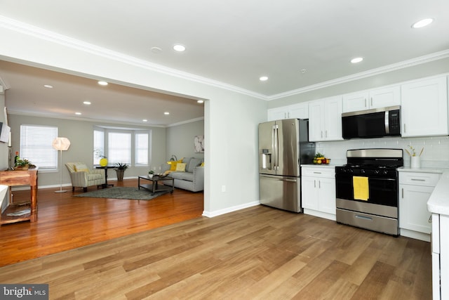 kitchen featuring light countertops, white cabinets, light wood-style floors, appliances with stainless steel finishes, and tasteful backsplash