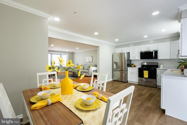 dining area featuring recessed lighting, wood finished floors, baseboards, and ornamental molding