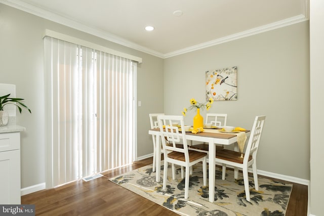 dining space featuring recessed lighting, crown molding, baseboards, and wood finished floors