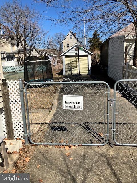 exterior space with an outbuilding, a gate, fence, and a shed