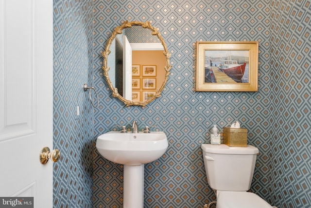 half bathroom with toilet and wallpapered walls
