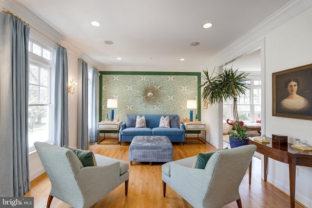 living room featuring crown molding, light wood finished floors, an accent wall, recessed lighting, and baseboards