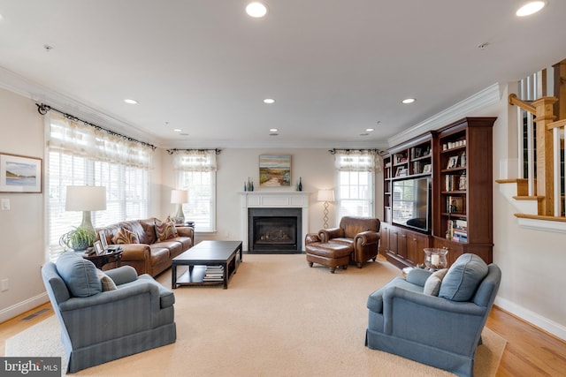 living room with recessed lighting, ornamental molding, and a fireplace with flush hearth