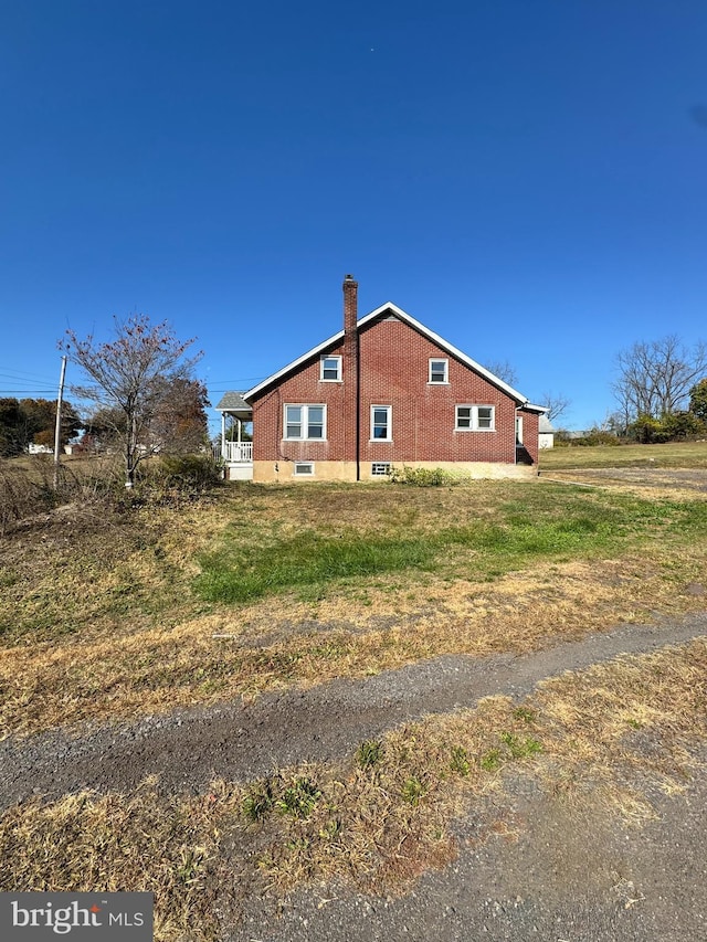 view of side of property featuring brick siding and a chimney