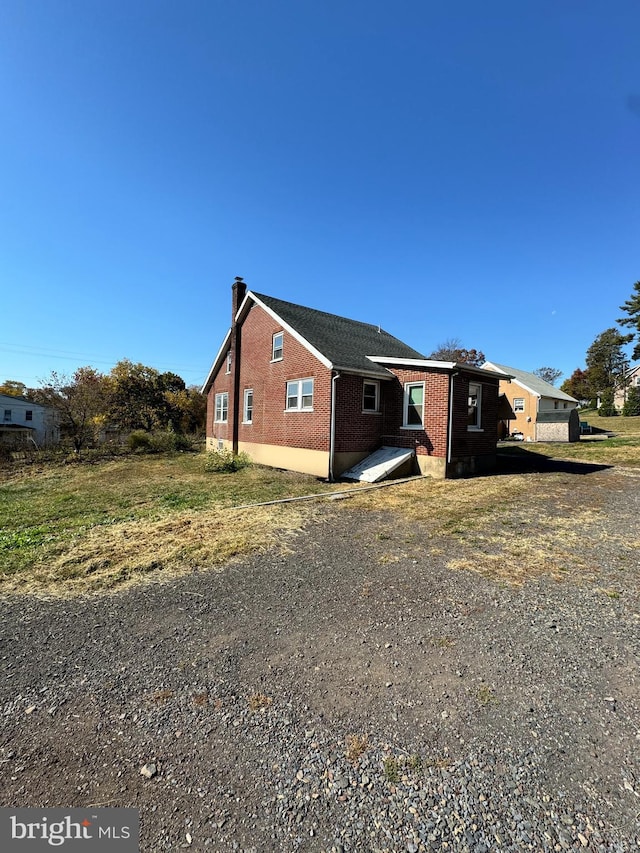 view of home's exterior with brick siding and a chimney