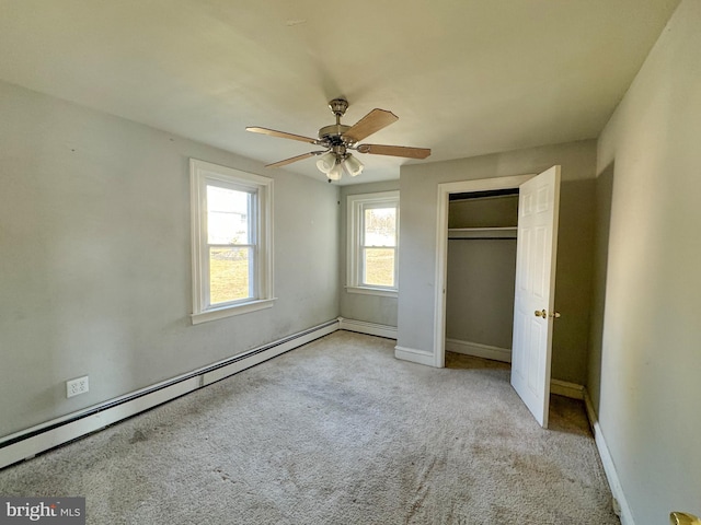 unfurnished bedroom with a ceiling fan, baseboards, a baseboard radiator, a closet, and carpet flooring